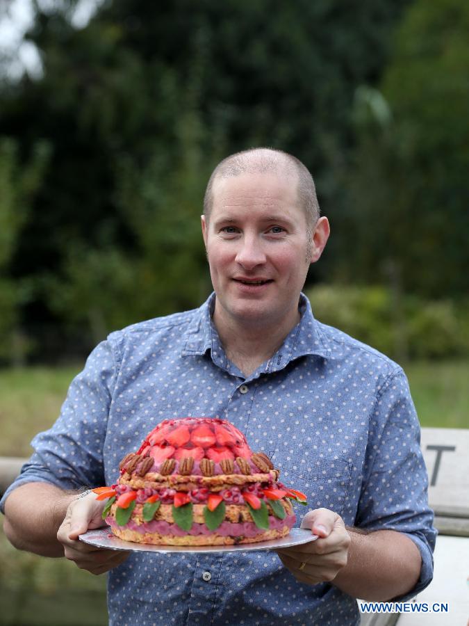 Runner-up on this year's Great British Bake Off Richard Burr holds the special birthday cake for London Zoo's oldest female gorilla Zaire at London Zoo in London, Britain, on Oct. 23, 2014. 