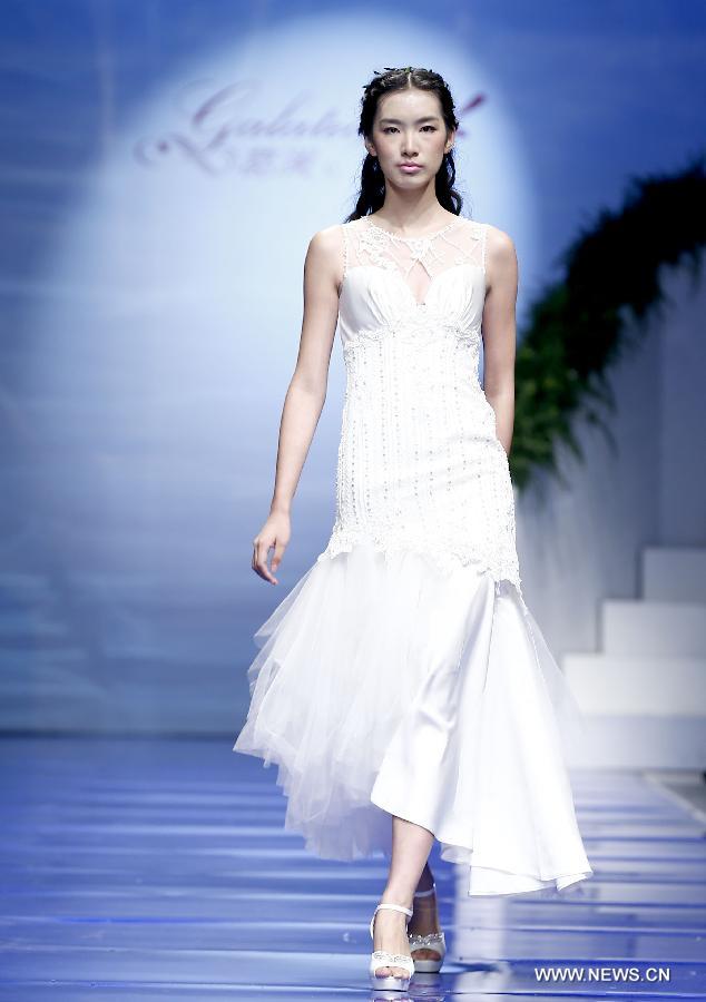 A model presents a wedding gown designed by Ren Chunhua during China Fashion Week in Beijing, capital of China, Oct. 26, 2014.