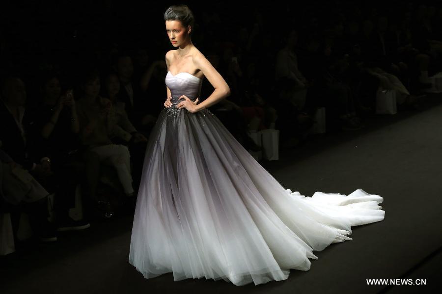 A model presents a wedding gown designed by Peng Jing during China Fashion Week in Beijing, capital of China, Oct. 26, 2014. 