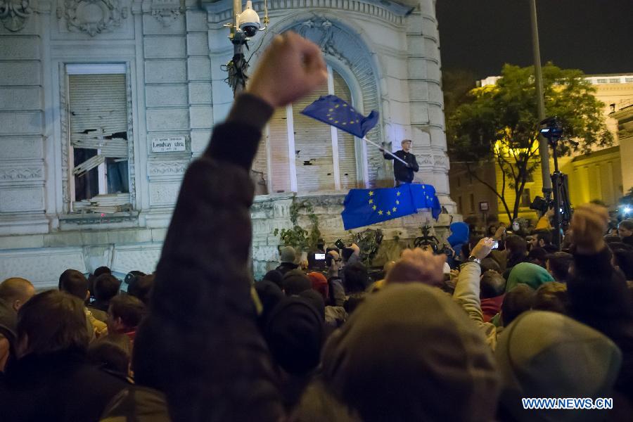 A demonstrator waves the EU flag on the balcony of the governing Fidesz party headquarters to protest against the planned internet tax on Heroes Square in Budapest, Hungary on October 26, 2014.