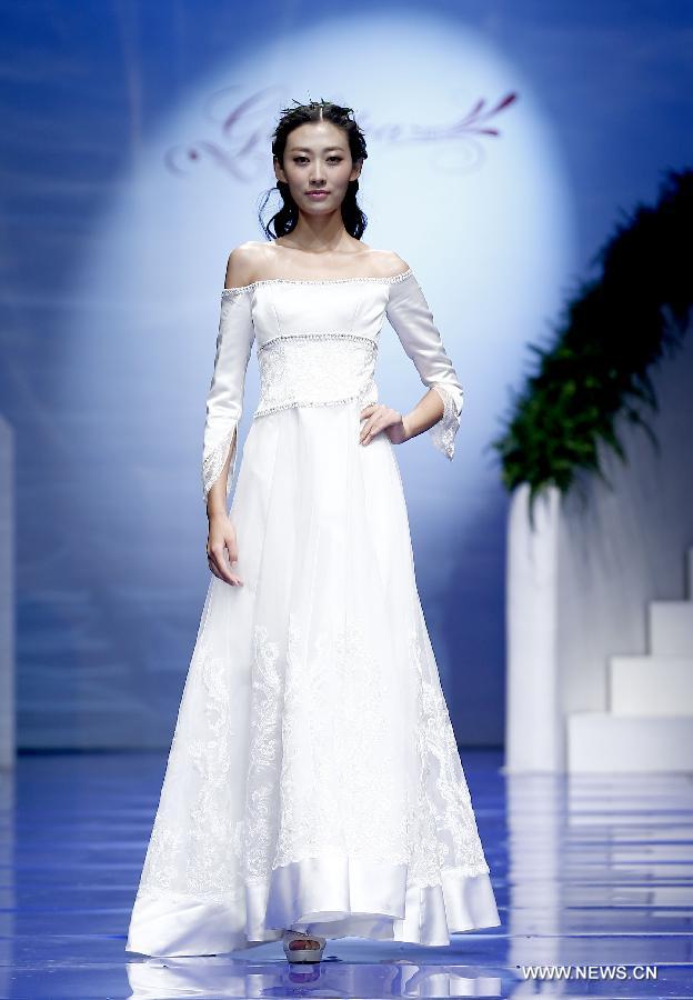 A model presents a wedding gown designed by Ren Chunhua during China Fashion Week in Beijing, capital of China, Oct. 26, 2014. 