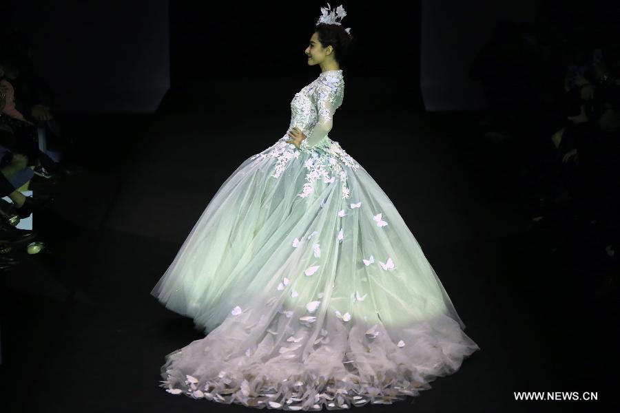 Olympic gymnastics champion Liu Xuan presents a wedding gown designed by Peng Jing during China Fashion Week in Beijing, capital of China, Oct. 26, 2014.