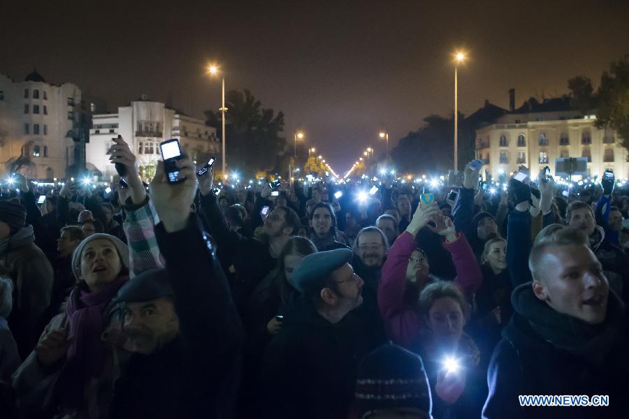 Thousands of demonstrators hold their phones in the air to protest against the planned internet tax on Heroes Square in Budapest, Hungary on October 26, 2014. 