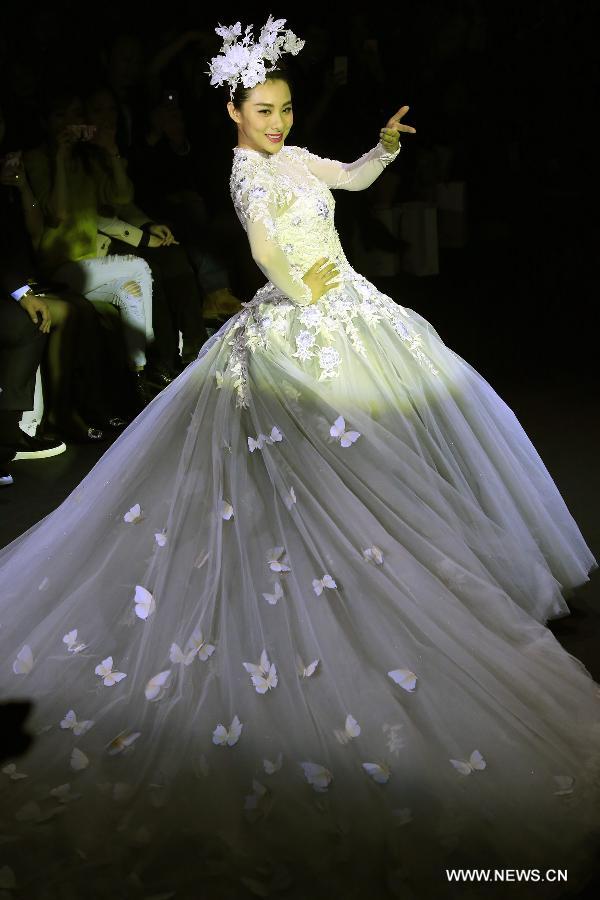 Olympic gymnastics champion Liu Xuan presents a wedding gown designed by Peng Jing during China Fashion Week in Beijing, capital of China, Oct. 26, 2014.