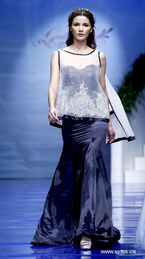 A model presents a wedding gown designed by Ren Chunhua during China Fashion Week in Beijing, capital of China, Oct. 26, 2014. 