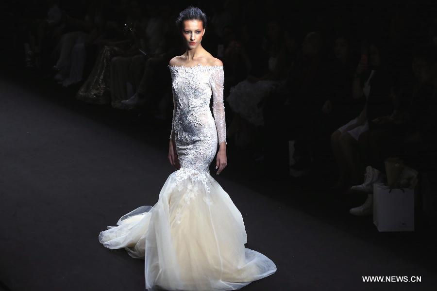 A model presents a wedding gown designed by Peng Jing during China Fashion Week in Beijing, capital of China, Oct. 26, 2014.