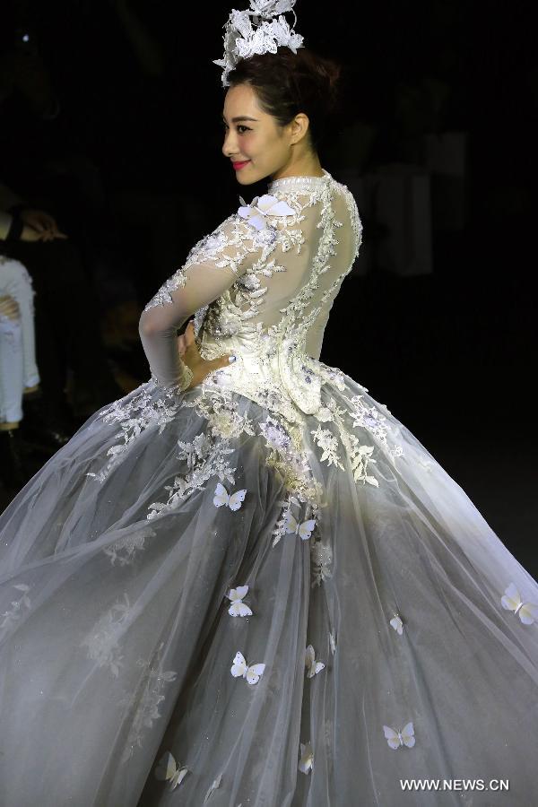 Olympic gymnastics champion Liu Xuan presents a wedding gown designed by Peng Jing during China Fashion Week in Beijing, capital of China, Oct. 26, 2014.