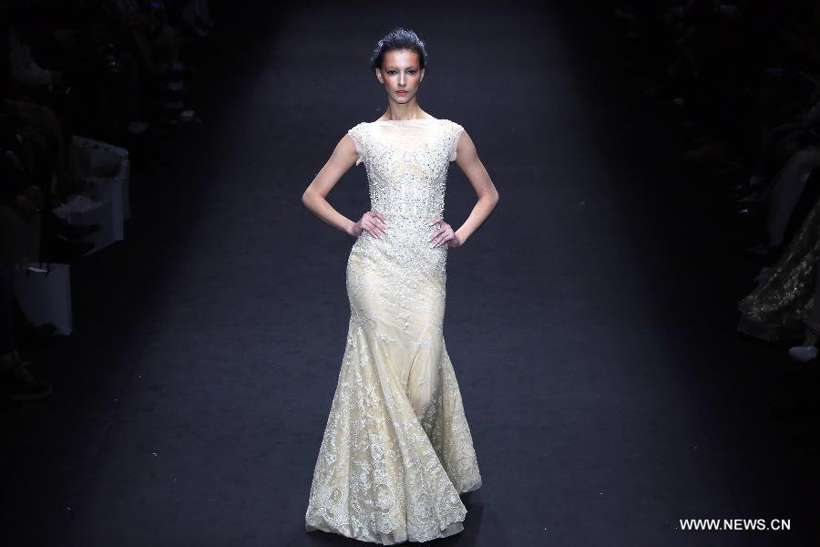 A model presents a wedding gown designed by Peng Jing during China Fashion Week in Beijing, capital of China, Oct. 26, 2014. 