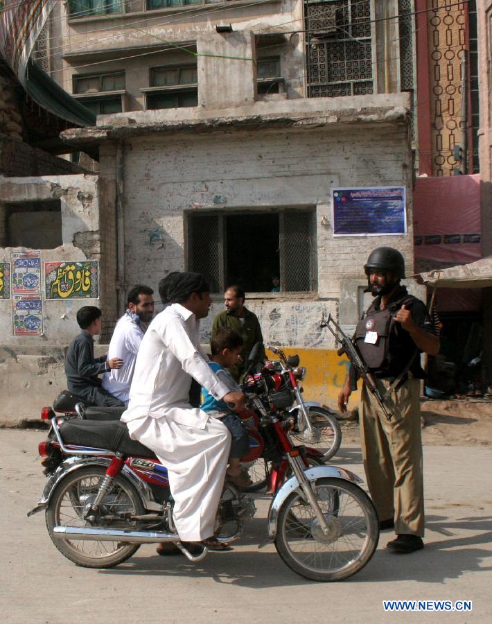 A policeman checks a motorbike rider due to security high alert during the Muslim month of Muharram in northwest Pakistan's Peshawar on Oct. 27, 2014.