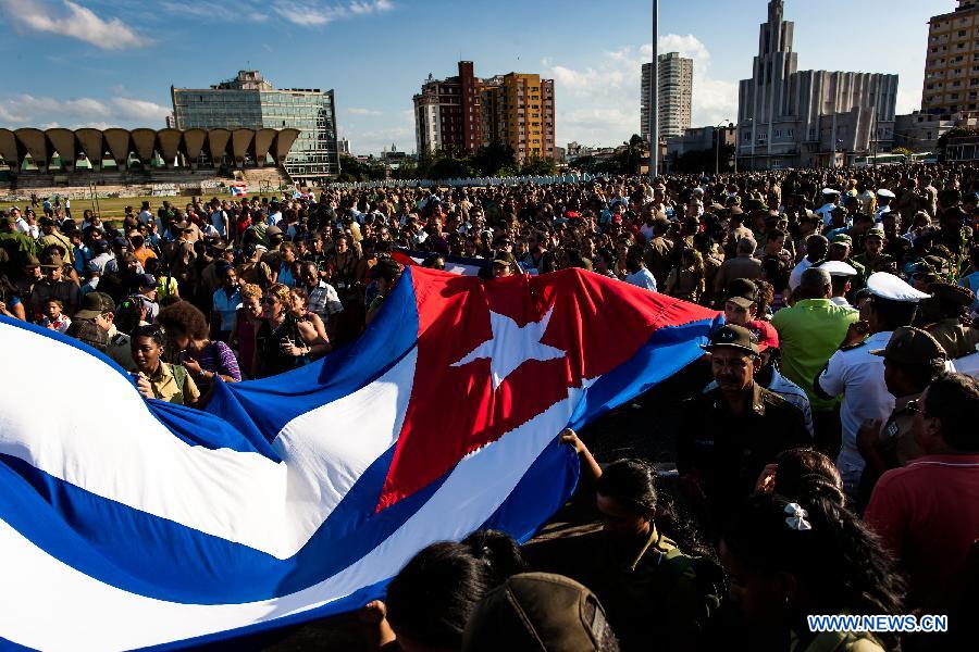 People march from the Revolutionary Square to the seaside to offer flowers to commemorate Camilo Cienfuegos, in Havana, capital of Cuba, on Oct. 28, 2014. 