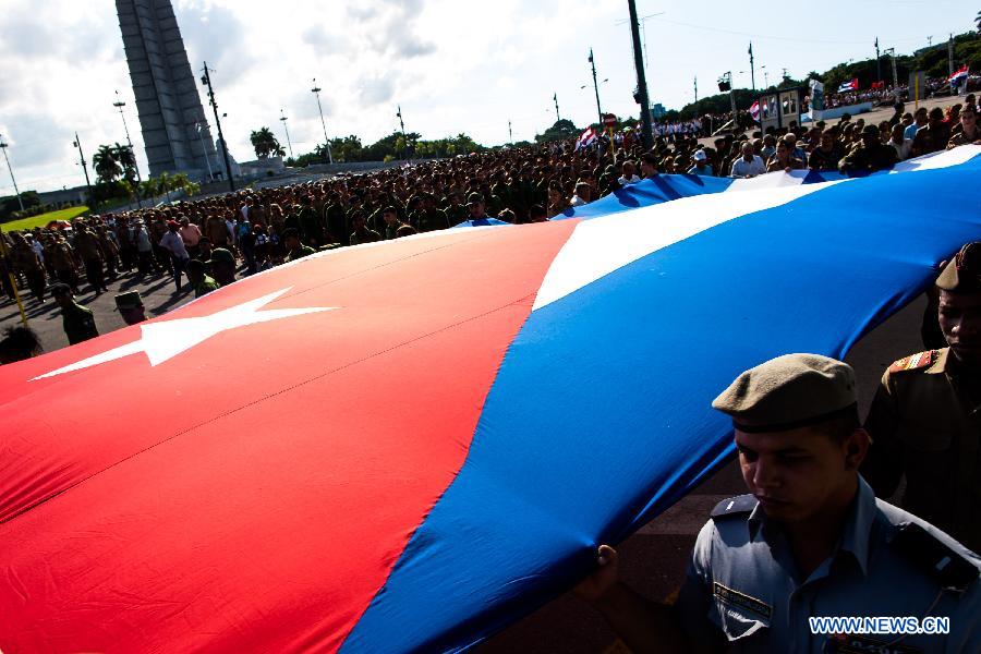 People march from the Revolutionary Square to the seaside to offer flowers to commemorate Camilo Cienfuegos, in Havana, capital of Cuba, on Oct. 28, 2014. 