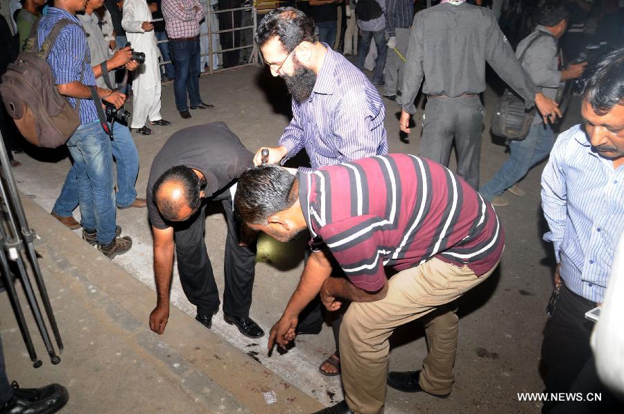 Pakistani security officials examine the blast site in southern Pakistani port city of Karachi on Oct. 28, 2014. 