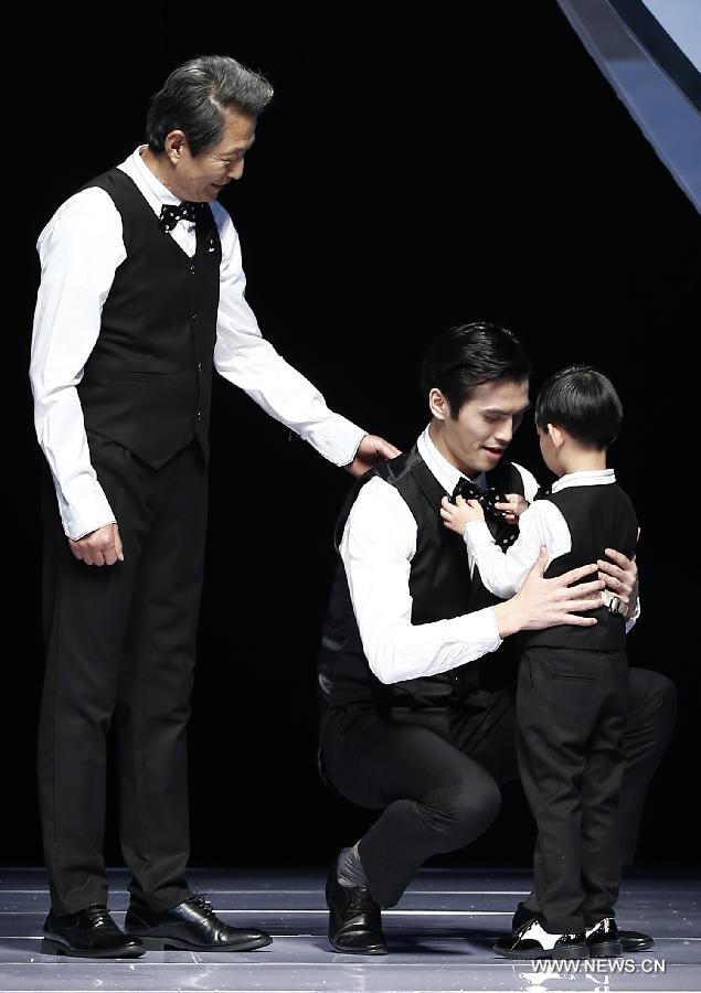 Two adults and a child model present creations designed by Dong Wenmei during China Fashion Week in Beijing, capital of China, Oct. 29, 2014. [Xinhua]