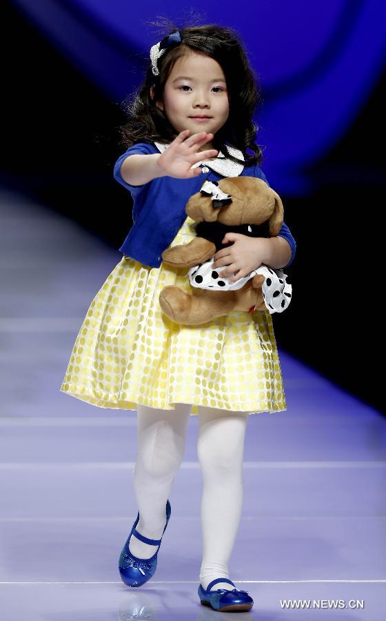 A child model presents a creation designed by Dong Wenmei during China Fashion Week in Beijing, capital of China, Oct. 29, 2014. [Xinhua]