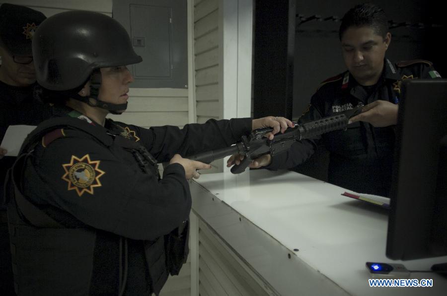 A member of the Civil Force receives his weapon for his night guard in Monterrey, Nuevo Leon, Mexico, on Oct. 29, 2014.
