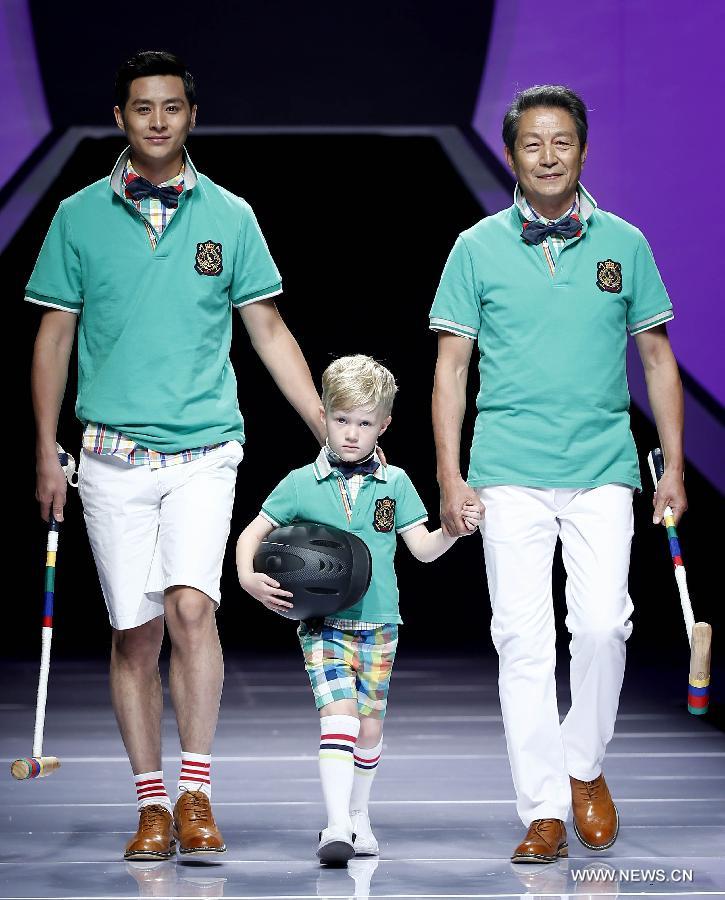 Two adults and a child model present creations designed by Dong Wenmei during China Fashion Week in Beijing, capital of China, Oct. 29, 2014. [Xinhua]