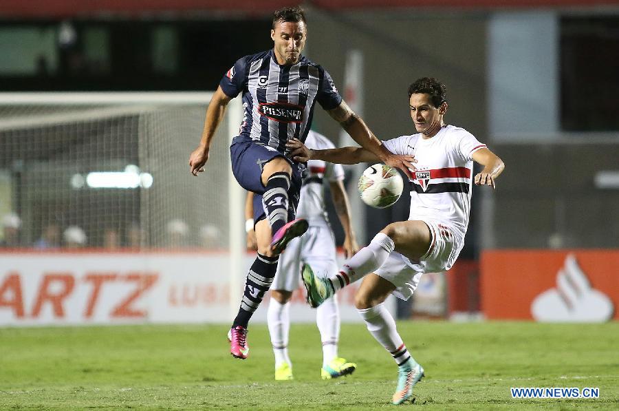 Paulo Henrique Ganso (R) of Brazil's Sao Paulo vies with Emanuel Herrera of Ecuador's Emelec during the first leg of the quarterfinals of the South American Cup at Morumbi stadium in Sao Paulo, Brazil, on Oct. 30, 2014.