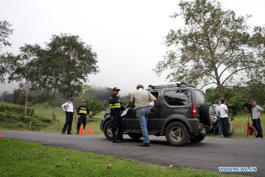 Officials of the National Emergencies Commission stand guard during a blockade towards the Turrialba Volcano, near Santa Cruz de Turrialba, 65km northeast of San Jose, capital of Costa Rica, on Oct. 30, 2014.