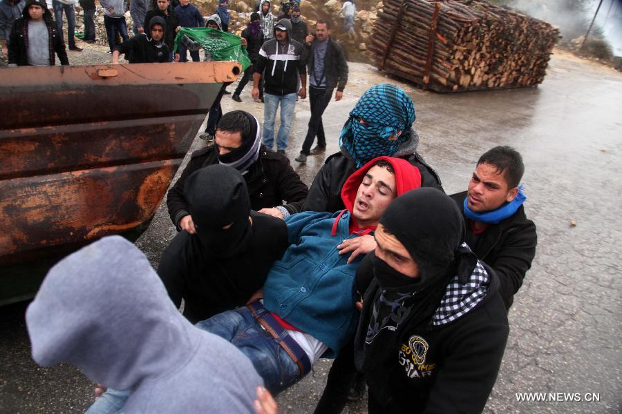 A wounded Palestinian protester is escorted away during clashes in the West Bank city of Hebron on Oct. 31, 2014. Clashes broke out Friday between Palestinian protestors and Israeli soldiers in several West Bank towns.(Xinhua/Mamoun Wazwaz) 