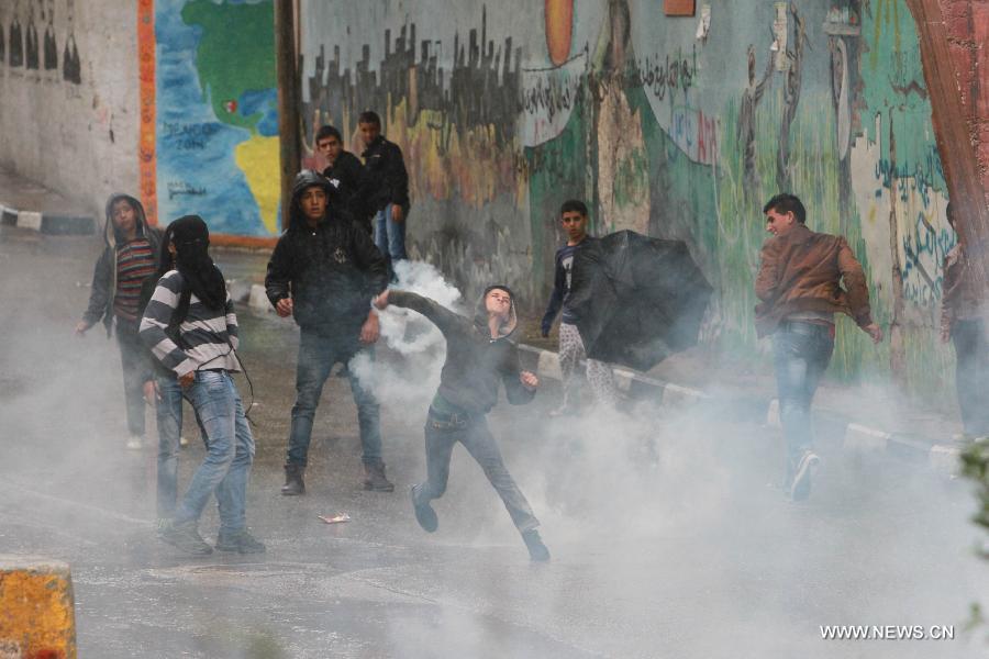 A Palestinian protester hurls stones toward Israeli soldiers during clashes in Aida refugee camp in the West Bank city of Bethlehem on Oct. 31, 2014. Clashes broke out Friday between Palestinian protestors and Israeli soldiers in several West Bank towns.(Xinhua/Luay Sababa) 