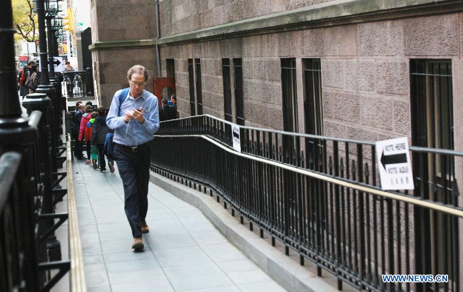 A registered elector leaves a polling station after casting his vote during the Midterm Elections in New York, the United States, on Nov. 4, 2014. 