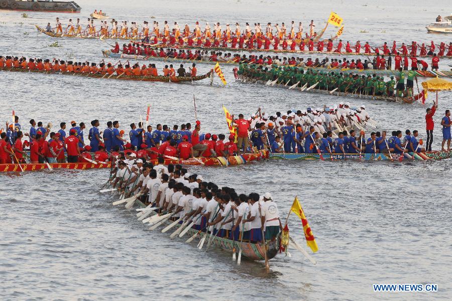 Racers row their boats in the river in front of the Royal Palace during the closing ceremony of the Water Festival in Phnom Penh, Cambodia on Nov. 7, 2014. 