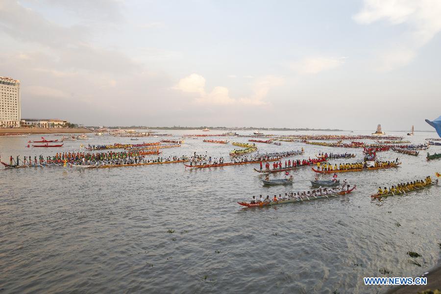 Racers row their boats in the river in front of the Royal Palace during the closing ceremony of the Water Festival in Phnom Penh, Cambodia on Nov. 7, 2014.