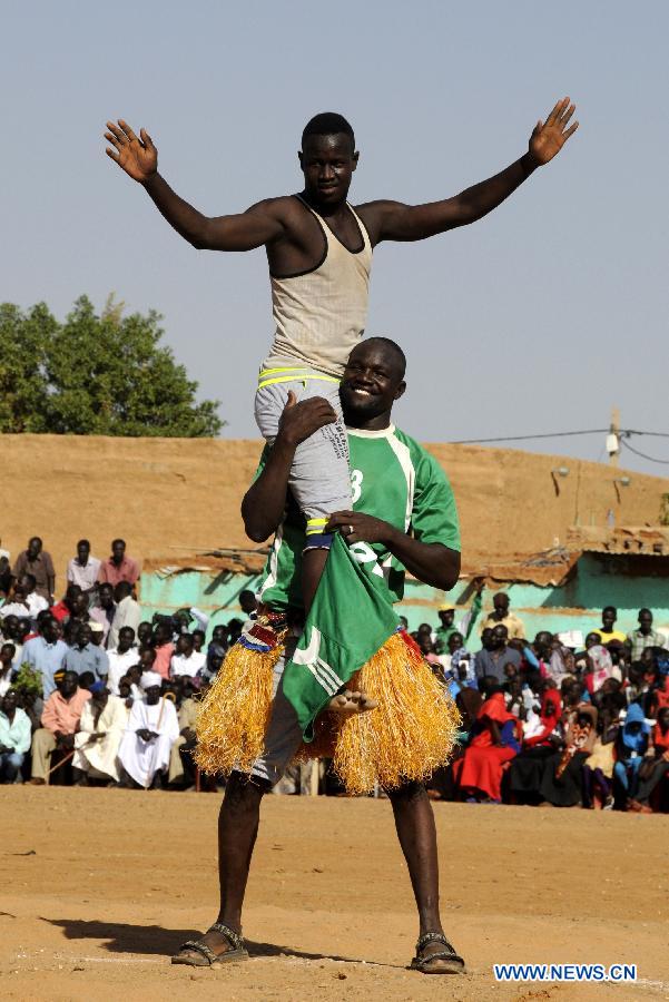 Nubian men cheer after winning a wrestle competition during the annual harvest festival in Omdurman, Sudan, Nov. 8, 2014. 