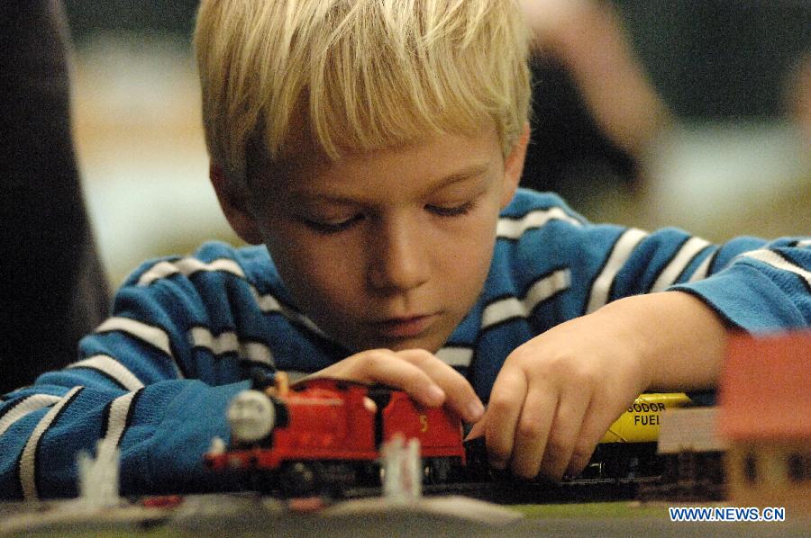A boy plays with model trains during the 32nd Model Railway Exhibition 'Trains 2014' in Burnaby, Canada, Nov. 8, 2014. 