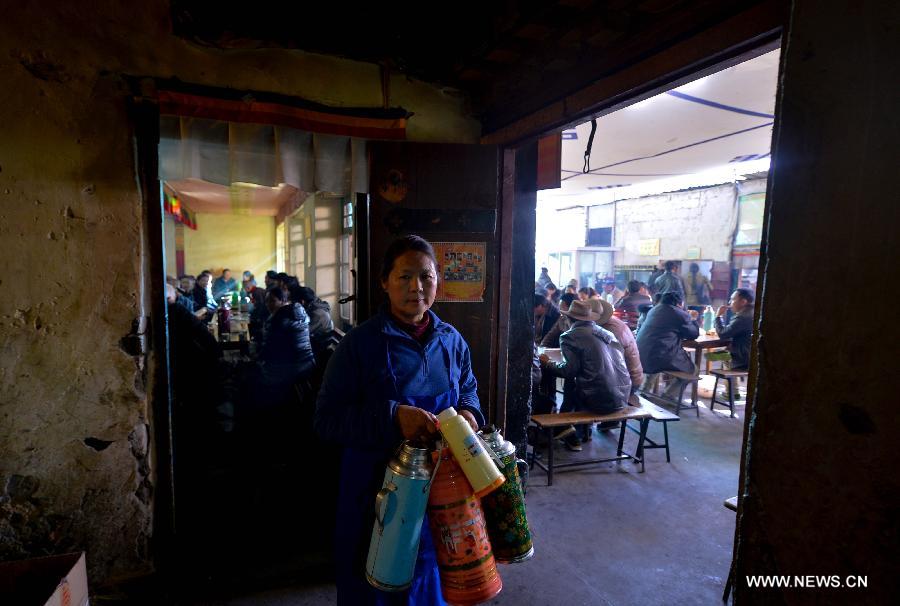 A waitress brings bottles of sweet tea to customers at a teahouse named Guangming in Lhasa, capital of southwest China's Tibet Autonomous Region, Nov. 11, 2014.