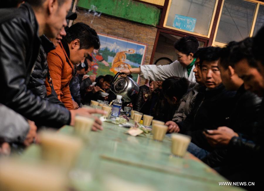 A waitress fills up cups with sweet tea at a teahouse named Guangminggangqiong in Lhasa, capital of southwest China's Tibet Autonomous Region, Nov. 7, 2014.
