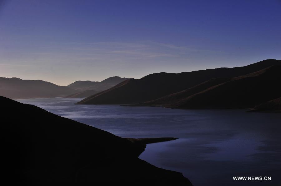 Photo taken on Nov. 9, 2014 shows the sunrise scenery at the Yamdrok Lake in Nagarze County of Shannan Prefecture, southwest China's Tibet Autonomous Region. The Yamdrok Lake, about 100 kilometers south of the region's capital Lhasa, is one of the three holy lakes in Tibet region. (Xinhua/Liu Kun) 