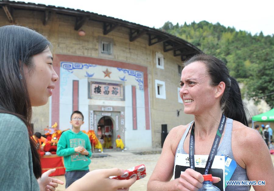 Kauri Mari (R) of Finland is interviewed after the 2014 Great Hakka Marathon in Nanjing County, southeast China's Fujian Province, on Nov. 15, 2014.