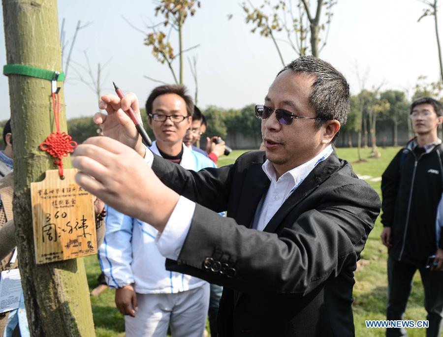 Zhou Hongyi, chairman of Qihoo 360 Technology Co. Ltd, signs a tag after planting a tree to mark the 2014 World Internet Conference in Wuzhen, east China's Zhejiang Province, Nov. 20, 2014. (Xinhua/Xu Yu)