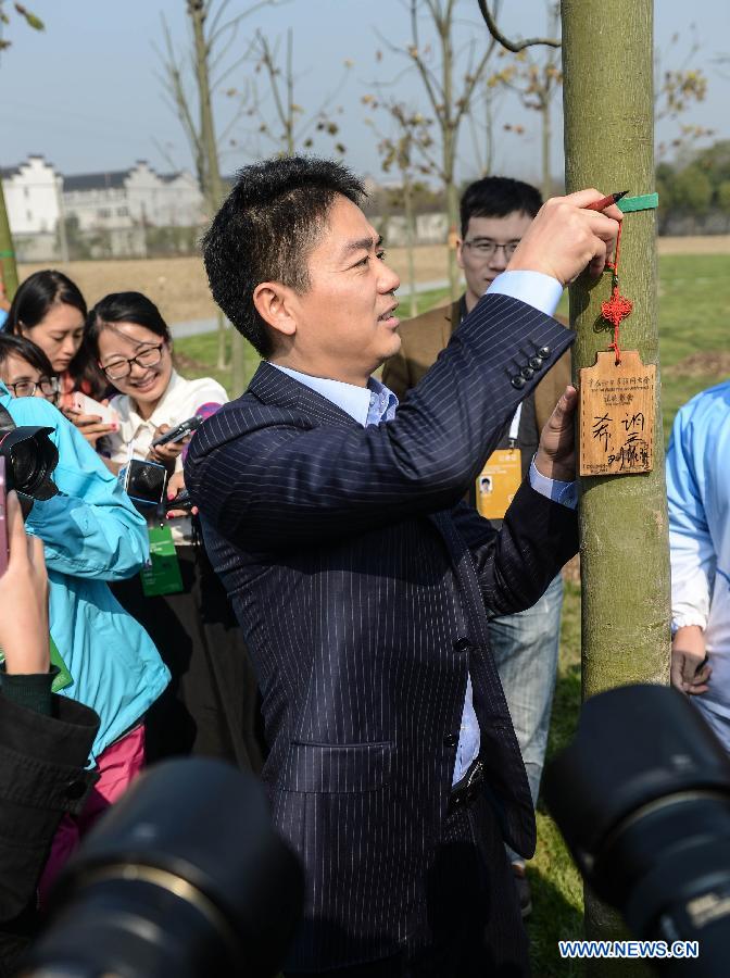 Liu Qiangdong (front), CEO of e-commerce company JD.com, signs a tag after planting a tree to mark the 2014 World Internet Conference in Wuzhen, east China's Zhejiang Province, Nov. 20, 2014. (Xinhua/Xu Yu)