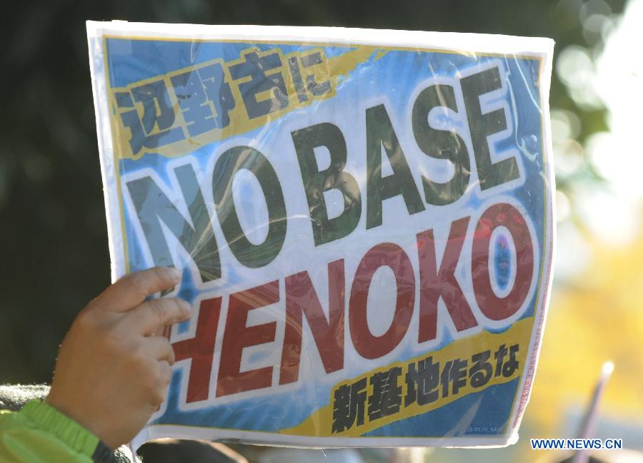 A man holds a banner to protest against U.S. bases in Okinawa in front of the Prime Minister's official residence in Tokyo, Japan, Nov. 22, 2014.