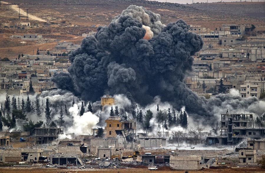 Smoke rises from the Syrian city of Kobani, following an airstrike by the US led coalition, seen from a hilltop outside Suruc, on the Turkey-Syria border, Nov. 17, 2014. Kobani, also known as Ayn Arab, and its surrounding areas, has been under assault by extremists of the Islamic State group since mid-September and is being defended by Kurdish fighters.