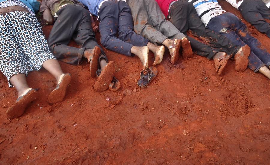 The bodies of some of the victims lie in a line on the ground, at the location of an attack on a bus about 50 kilometers (31 miles) outside the town of Mandera, near the Somali border in northeastern Kenya, Nov. 22, 2014. Somalia's Islamic extremist rebels, al-Shabab, attacked the bus in northern Kenya at dawn on Saturday, singling out and killing 28 passengers who could not recite an Islamic creed and were assumed to be non-Muslims, Kenyan police said. (Xinhua/AP Photo)