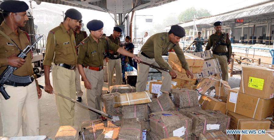 Security personnel check cartons after a powerful explosive was recovered from the Guwahati bound Inter-City express in Kedukona Railway station in Assam, India, Nov. 24, 2014.