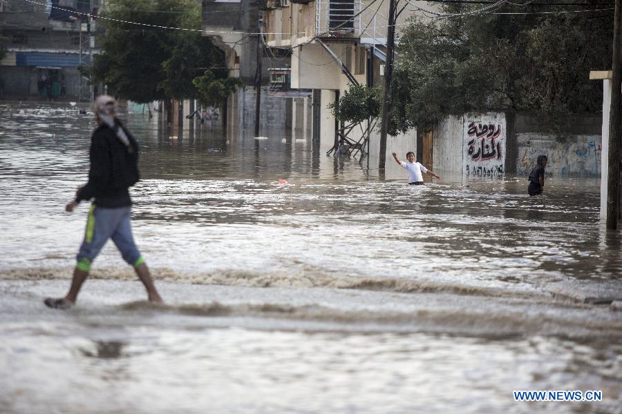 Palestinians walk through a flooded road following heavy rain in Gaza City on Nov. 27, 2014.