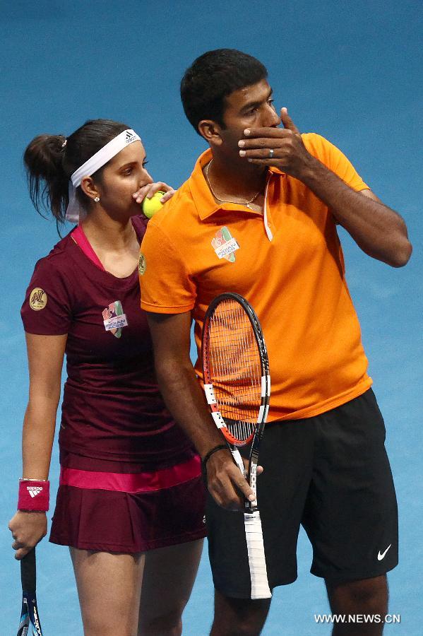 Micromax Indian Aces player Sania Mirza and Rohan Bopanna talk to each other during the mixed doubles match against players of UAE Royals in the International Premier Tennis League in Pasay City, the Philippines, on Nov. 30. 2014. 