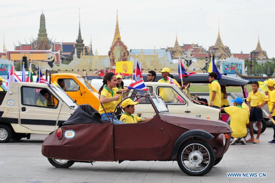 People participate in antique cars parade as part of the celebration of Thai King's 87th Birthday Anniversary in front of Grand Palace in Bangkok, Thailand, Dec. 4, 2014. 