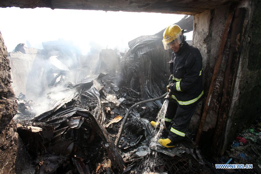 A firefighter puts out a fire that hit a slum area in Manila, the Philippines, Dec. 11, 2014.