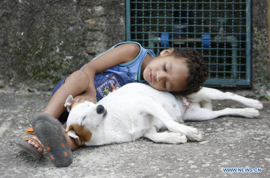 Miguel plays with the dog named Pitucha in Ibiritem in the metropolitan area of Belo Horizonte, Minas Gerais, Brazil, on Dec. 11, 2014. 