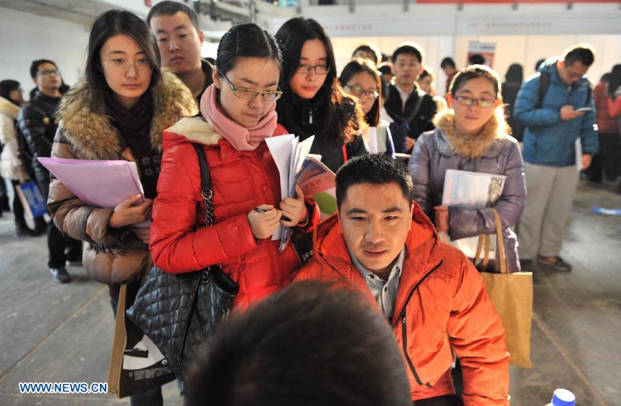 A job seeker receives interview at a job fair for postgraduates in Beijing, capital of China, Dec. 18, 2014. About 18,000 opportunities were offered at the fair. (Xinhua/Li Wen)