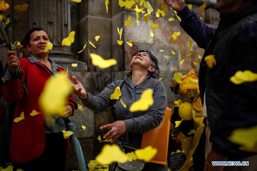 Residents play with papercuts of butterflies in front of the Primary Cathedral during the homage of late Latin American writer Gabriel Garcia Marquez in Bogota, Colombia, on April 22, 2014.
