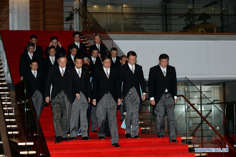 The re-elected Japanese Prime Minister Shinzo Abe (C, 1st row) and his new cabinet walk to take a group photo in Tokyo, Japan, Dec. 24, 2014. 