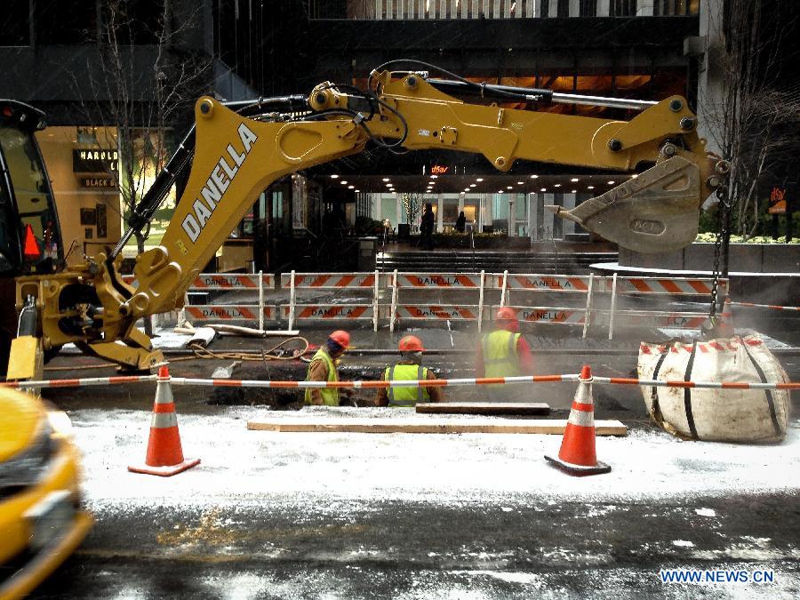 Workers conduct road maintenance operation during a snowfall in New York, the United States, Jan. 6, 2015.