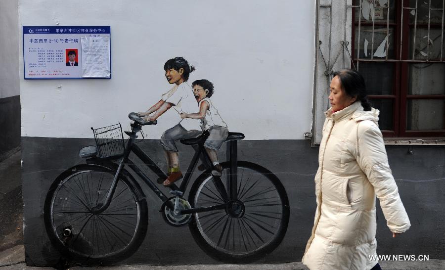 A woman walks past a cartoon mural in a residential community of Changsha, capital of central China's Hunan Province, Jan. 15, 2015. The exterior walls of a residential community in Changsha have been rejuvenated, after a group of young cartoonists were invited to create some 40 cartoon murals on them. The mural painters not only drew on plain walls, but also blended their work with the environment by integrating objects on the scene (newspaper boxes, electricity meter cases, air-conditioning units, etc.) into the murals. (Xinhua/Li Ga)