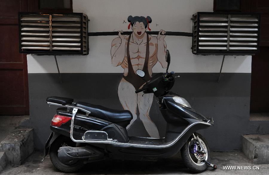A cartoon mural which takes advantage of two air-conditioning units is seen in a residential community of Changsha, capital of central China's Hunan Province, Jan. 15, 2015. The exterior walls of a residential community in Changsha have been rejuvenated, after a group of young cartoonists were invited to create some 40 cartoon murals on them. The mural painters not only drew on plain walls, but also blended their work with the environment by integrating objects on the scene (newspaper boxes, electricity meter cases, air-conditioning units, etc.) into the murals. (Xinhua/Li Ga)